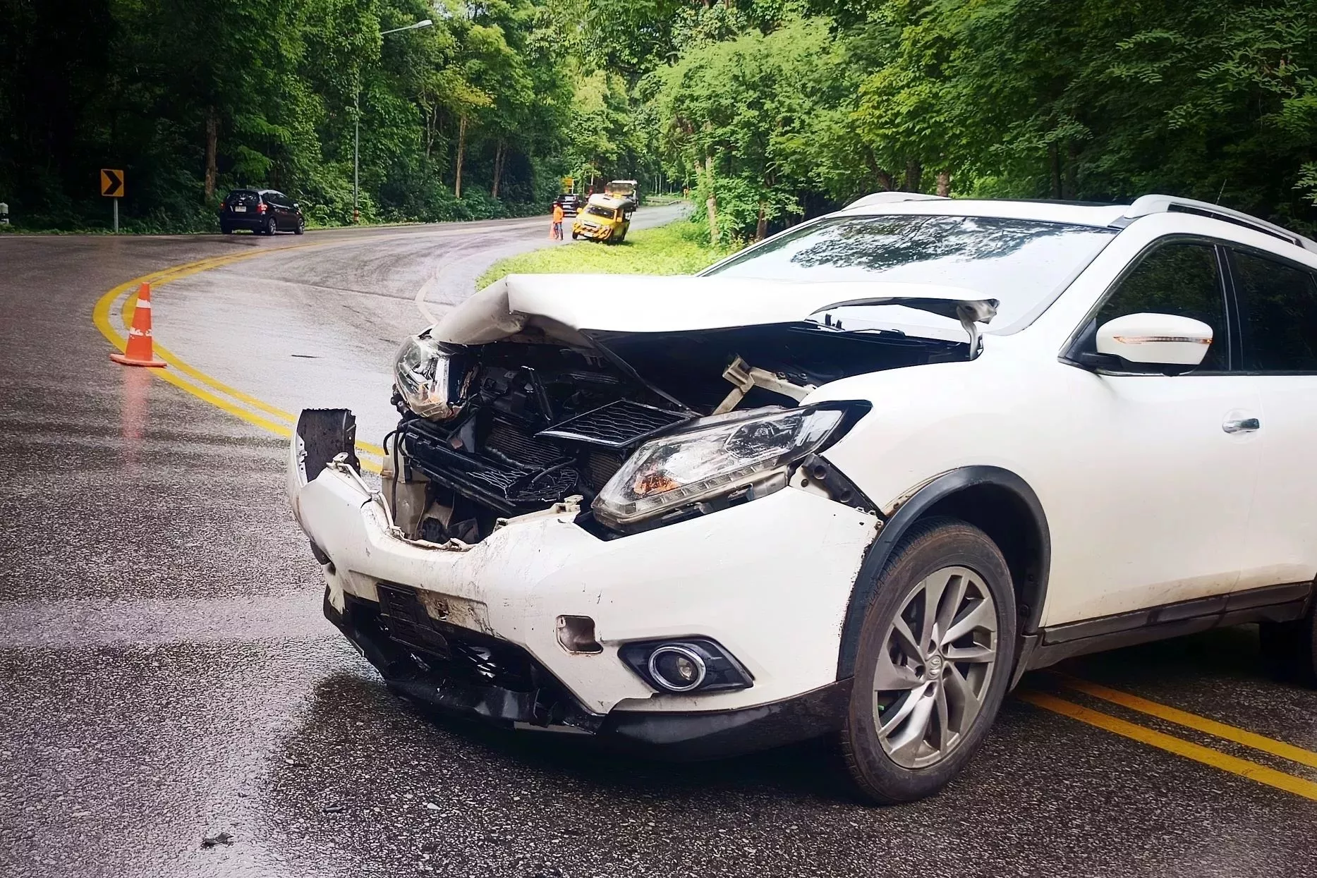 weißes Auto mit geschädigter Front nach Unfall